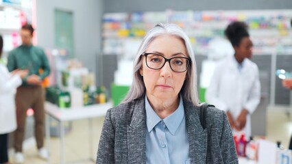 Senior woman choosing medical pills in pharmacy. Female customer holding packaged pill. Older woman...