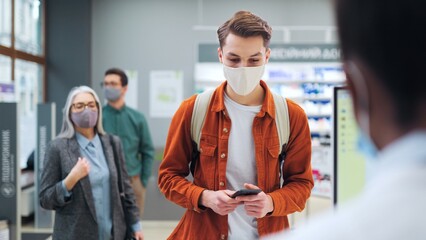 Man in protective mask and having fever symptoms. Male customer buying pills by medical...