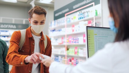 Man in protective mask and having fever symptoms. Male customer buying pills by medical...