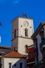 Fototapeta premium A charming view of a cobblestone alley in Summonte, a picturesque Italian village. The scene showcases colorful houses with wooden doors and balconies under a bright blue sky, capturing the essence