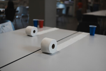 Toilet paper rolls and plastic cups arranged on a dining table. Concept of creative and active indoor play for children