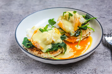 eggs benedict and spinach on a plate as a breakfast menu