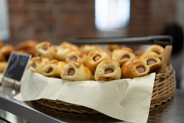 Sausage in batter placed in a wicker basket on a display case in the dining room next to a price...