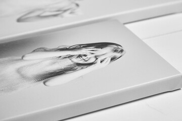 Side view of a black and white canvas print featuring a joyful child, stretched on a wooden stretcher bar with gallery wrapping. Fine texture and high-quality detail