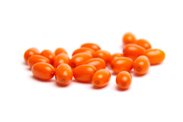 A collection of bright orange sea buckthorn berries with a smooth, glossy texture, spread out on a white background. Rich in antioxidants and commonly used in health foods