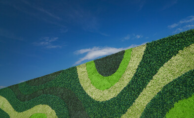 The green wall is made of various types of artificial plastic plants and different shades of green....