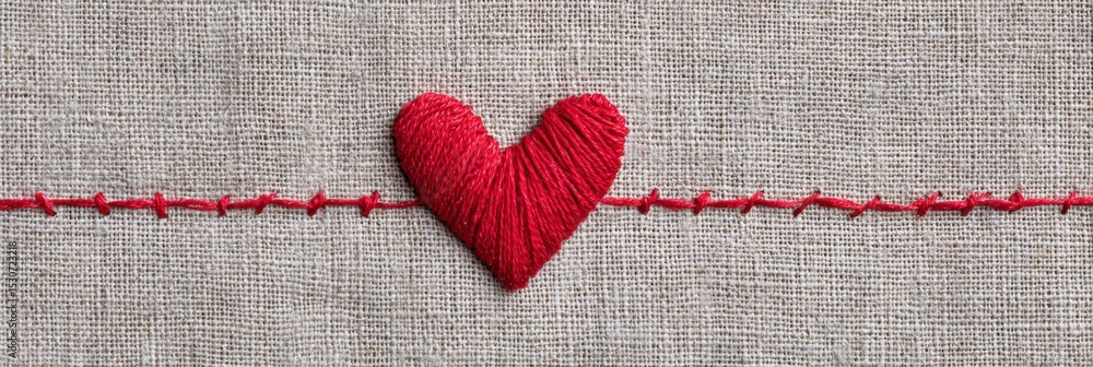 Poster red thread stitched heart on linen texture showcases artistry and craft in a warm and inviting setti