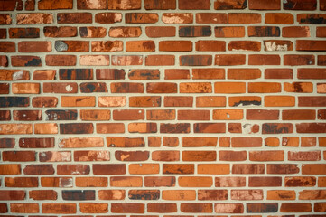 Obraz premium The old red brick wall The bricks show natural variations in color, from deep reds to oranges and browns, conveying a sense of age and classic architectural texture.