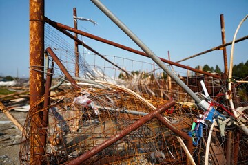 A close-up of a rusty metal structure in a polluted environment with debris.