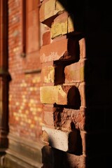 Close up of a weathered brick wall in warm sunlight and shadows