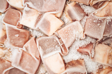 Close-up of frozen food packs with ice crystals on a cold surface