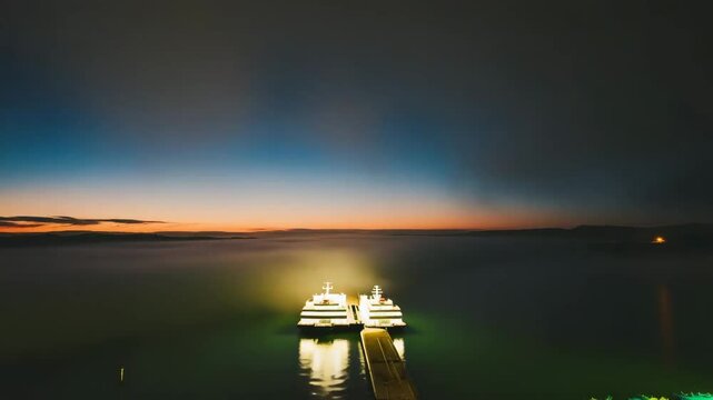 Illuminated Ferry Dock at Night Over Calm Dark Water
