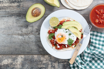 Huevos Rancheros on wooden table. Top view. Copy space. Traditional Mexican breakfast