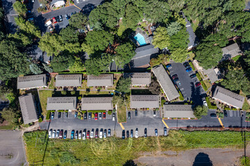 Aerial drone picture of a beautiful residential apartment complex in Cedar Mill, Portland, OR, captured at morning. Photo shows green courtyards, swimming pool, parking lots and housing buildings	
