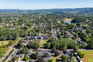 Aerial drone picture of a beautiful residential apartment complex in Cedar Mill, Portland, OR, captured at morning. Picture shows green courtyards, a lake, parking lots and housing buildings	
