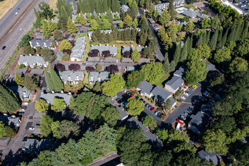 Aerial drone picture of a beautiful residential apartment complex in Cedar Mill, Portland, OR, captured at morning. Picture shows green courtyards, parking lots and housing buildings	
