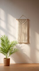 Living room wall has macrame and a potted plant. Interior decor, house, sunlight, art, lifestyle