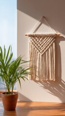 Plant and macrame wall art sit on a wooden shelf. Home decor, boho style, handmade, craft.