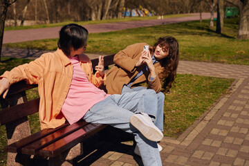 Multicultural friends share laughter while enjoying a sunny day in the park