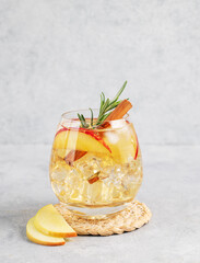Apple cocktail or cider  with ice, garnished with cinnamon and rosemary  in a glass on a light...