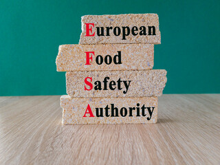 Brick blocks with the expression EFSA - European Food Safety Authority. Beautiful green background....