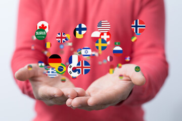 Image of hands gently cradling numerous flags representing global unity and international...