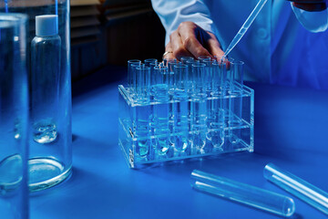 Scientist hand dropping chemical liquid into test tube, science research, medical trial  and development concept.