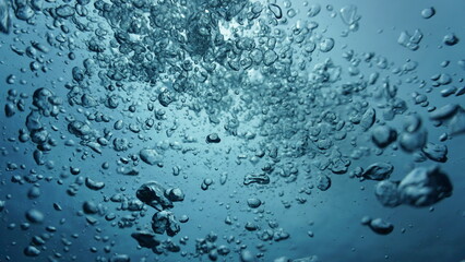 Underwater art photography. Air bubbles going towards the surface in sunlight in the deep blue sea.