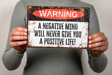 Warning Sign with Motivational Quote About Mindset and Positive Thinking Held by Person