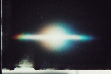 Old film light leaks texture with scratches, noise, iridescent light. Rainbow lens flare effect, camera film filter with bokeh, dust, grain. Distressed retro movie, photo burn effect.