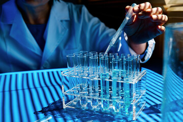 Scientist hand dropping chemical liquid into test tube, science research, medical trial  and...