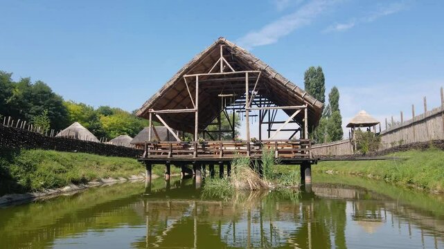 Exploring Keltsko selo with its traditional structures and serene surroundings near a reflective pond