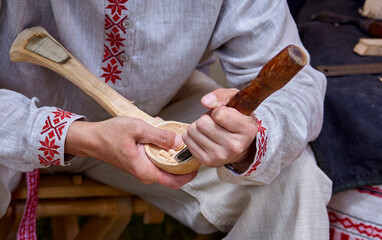 A Craftsman's Delicate Touch: Carving a Wooden Bowl in the Warm Light of a Workshop