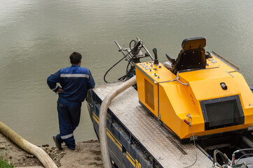 Worker next to car for draining water bodies