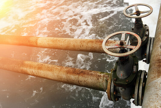 Old water treatment plant pipes and valves showing signs of wear and rust during daytime