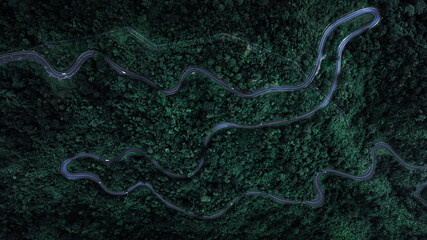 aerial top view beautifull curve road on green forest in the rain season background, rural routes...