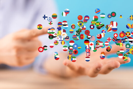 Image of hands holding many flags, symbolizing global unity and international connections.