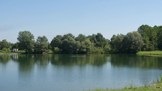 Calm day at Ivanovacka ada in Serbia with peaceful water reflections and lush greenery
