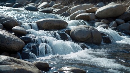 Fototapeta premium A rocky stream featuring water flowing over the rocks, with the water being clear and the rocks displaying shades of brown and gray.