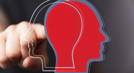 Stock photo of a hand pointing at overlapping head silhouettes, symbolizing understanding different...