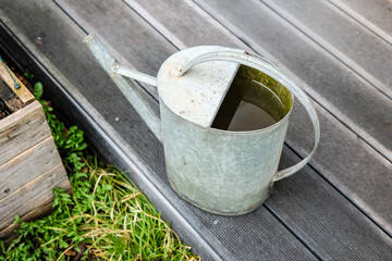 Decorative vintage metal watering can in the garden