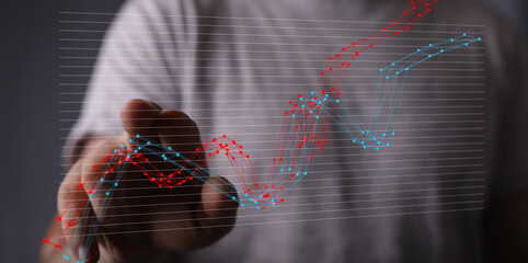 Hand interacting with a digital graph showing market trends and financial data analysis.