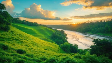A grassy hillside gazes upon a winding river snaking through a valley illuminated by the warm glow of a summer sunset.