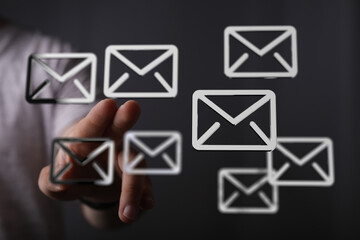 Hand interacting with email icons, showcasing email management and communication.