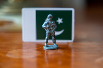 A tin soldier on the background of the flag of Pakistan. India Pakistan military conflict