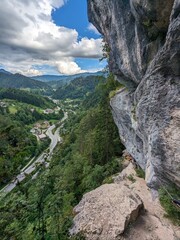 Climber ascending Koschlak Klettersteig via ferrata route in Austrian Alps on secured rock faces.