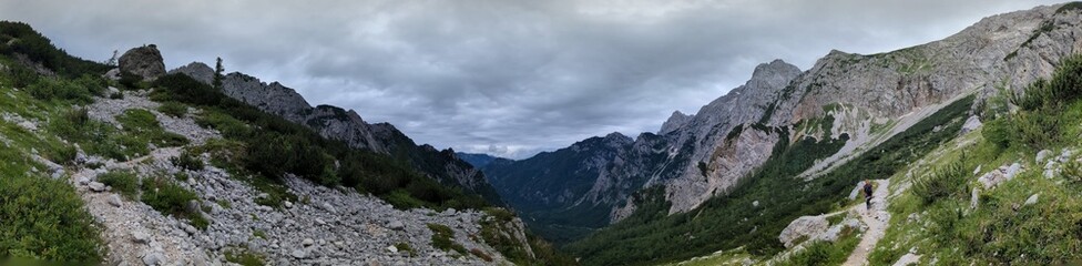 Panoramic view of Logarska dolina valley with peaks of Slovenian Alps covered by passing clouds.
