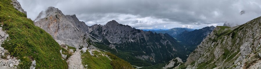 Panoramic view of Logarska dolina valley with peaks of Slovenian Alps covered by passing clouds.