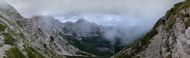 Panoramic view of Logarska dolina valley with peaks of Slovenian Alps covered by passing clouds.