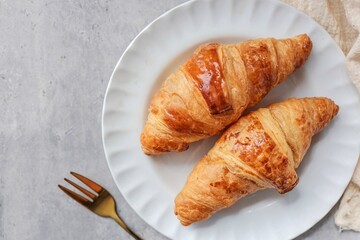 Close up of Two croissant in white plate on grey background , top view food table